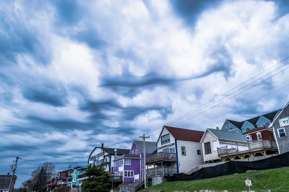 Storm clouds building over houses before roof damage in Jackson, MS